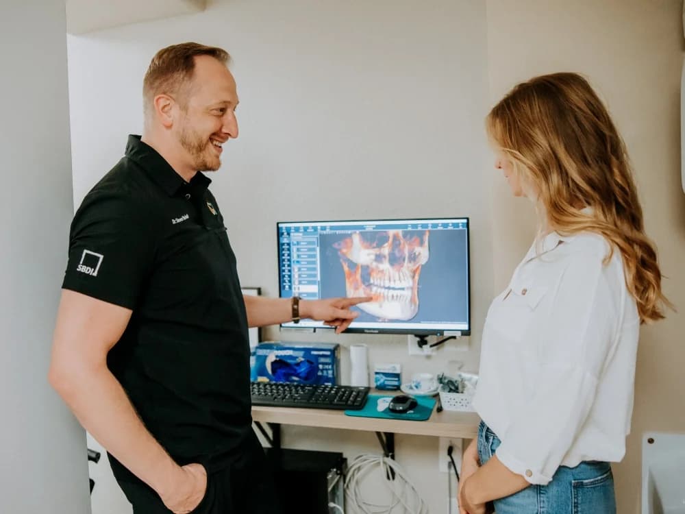 Doctor reviewing a 3D scan with a patient during an All-on-4 consultation